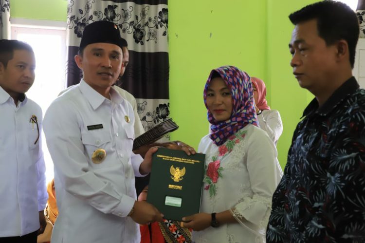SERAHKAN SERTIFIKAT. Bupati Lampung Barat menyerahkan sertifikat tanah program PTSL, Rabu (4/12). DOKUMENTASI PEMKAB LAMPUNG BARAT