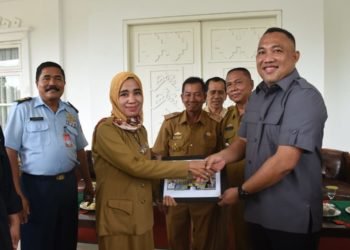 BERI KENANG-KENANGAN. Bupati Tulangbawang Barat Umar Ahmad memberikan cendera mata kepada orang tua asuh Pengajar Cerdas Angkatan IV, menandai selesainya tugas mereka, Senin (16/12). LAMPUNG POST/AHMAD SOBIRIN