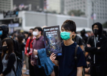 DUKUNG ETNIS UIGHUR. Seorang demonstran memegang poster saat rapat umum di Hong Kong, Minggu (22/12) untuk menunjukkan dukungan kepada minoritas Uighur di Tiongkok. (ANTHONY WALLACE/AFP)