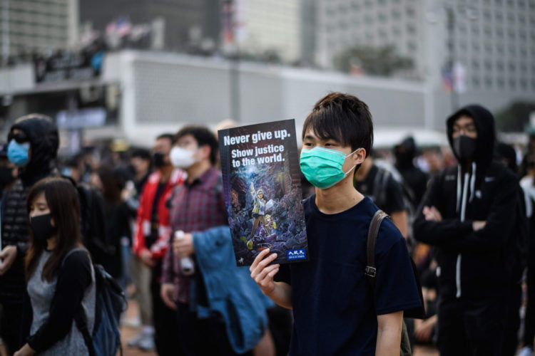 DUKUNG ETNIS UIGHUR. Seorang demonstran memegang poster saat rapat umum di Hong Kong, Minggu (22/12) untuk menunjukkan dukungan kepada minoritas Uighur di Tiongkok. (ANTHONY WALLACE/AFP)