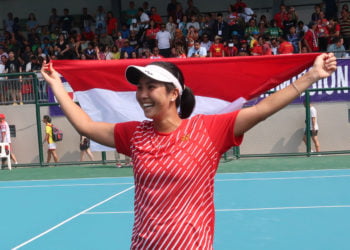 EMAS TUNGGAL PUTRI: Petenis tunggal putri Indonesia Aldila Sutjiadi membawa bendera Merah Putih setelah menang 6-0 dan 7-5 atas petenis Vietnam Savanna Ly Nguyen pada final tenis tunggal putri SEA Games 2019 di lapangan Rizal Memorial Tennis Centre, Manila, Filipina, Jumat (6/12). (ANTARA/MICHAEL SIAHAAN)