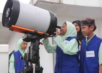 MENGAMATI BENDA LANGIT. Reporter Cilik Lampung Post sedang mengamati benda langit lewat teropong. Teropong Celestron ini biasanya digunakan untuk mengamati kabut atau gas yang ada di luar angkasa (nebula). LAMPUNG POST/SUKISNO