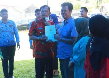 BAGIKAN SERTIFIKAT Bupati Pesisir Barat Agus istiqlal membagikan secara simbolis 831 sertifikat tanah yang dibuat melalui program Pendaftaran Tanah Sistematis Lengkap (PTSL) kepada warga di kecamatan Krui Selatan, Kamis (18/12). LAMPUNG POST/ YON FISOMA