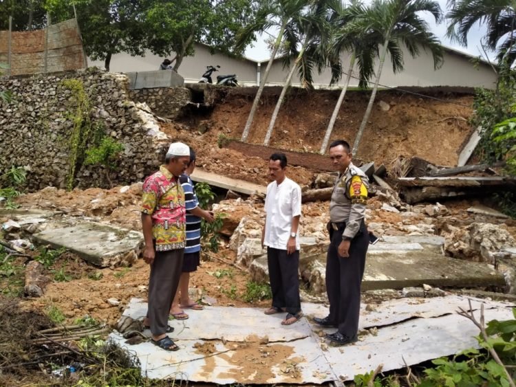 TINJAU LONGSOR DAN TEMBOK ROBOH. Lurah Campangjaya, Kecamatan Sukabumi, Bandar Lampung, M Rahmad (baju putih), Bhabimkamtibmas Campangjaya Hariyadiyansyah, Ketua RT 06 Deri, Ketua RT 07 Joni Tangkari saat meninjau lokasi musibah di Jalan P Tirtayasa, Gang Fatimah Nomor 38 RT 06/LK 1, Kampung Beringinraya, Rabu (1/1). n LAMPUNG POST/EKA SETIAWAN