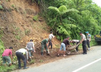 BERSIHKAN MATERIAL. Polsek Sekincau bersama masyarakat dan Koramil setempat membersihkan material longsor, di Pekon Gihamsukamaju, Selasa(28/1). DOK POLSEK SEKINCAU