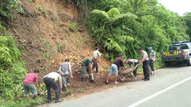 BERSIHKAN MATERIAL. Polsek Sekincau bersama masyarakat dan Koramil setempat membersihkan material longsor, di Pekon Gihamsukamaju, Selasa(28/1). DOK POLSEK SEKINCAU