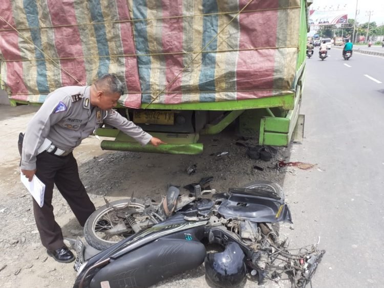 MOTOR HANCUR. Polisi menunjukkan motor pengendara yang hancur akibat menabrak badan truk yang parkir di depan Hotel Mini, Natar, Minggu (12/1). DOK WARGA