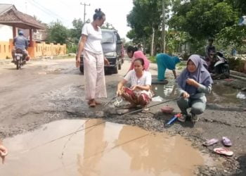 WARGA PROTES. Sejumlah warga Desa Sukaraja, Kecamatan Palas, Lampung Selatan, melakukan protes dengan cara memancing ikan di kubangan jalan poros kecamatan setempat, Rabu (29/1). LAMPUNG POST/ARMANSYAH