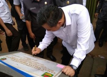 TANDA TANGANI PRASASTI. Bupati Pesawaran Dendi Ramadhona menandatangani prasasti saat meresmikan Water Boom Desa Tri Rahayu, Kecamatan Negerikaton, Rabu (15/1). LAMPUNG POST/PUTRA PANCASILA SAKTI