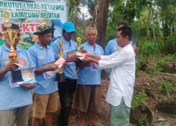 PEMENANG LOMBA. Hipni, bakal calon bupati Lampung Selatan, diwakili Hipni Center, Herwansyah, menyerahkan hadiah kepada pemenang lomba burung perkutut lokal di Desa Bangunrejo, Kecamatan Ketapang, Rabu (1/1). LAMPUNG POST/AAN KRIDOLAKSONO
