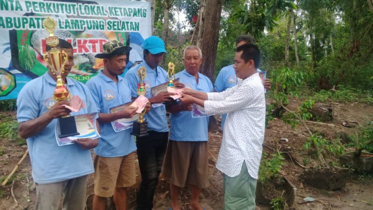 PEMENANG LOMBA. Hipni, bakal calon bupati Lampung Selatan, diwakili Hipni Center, Herwansyah, menyerahkan hadiah kepada pemenang lomba burung perkutut lokal di Desa Bangunrejo, Kecamatan Ketapang, Rabu (1/1). LAMPUNG POST/AAN KRIDOLAKSONO