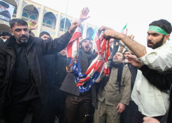 SIAP BALAS DENDAM. Warga Iran membakar bendera AS dalam demonstrasi menentang "kejahatan" Amerika Serikat atas terbunuhnya Pengawal Revolusi Iran Mayor Jenderal Qasem Soleimani di
Teheran, Jumat (3/1). Iran memperingatkan "balas dendam berat" dan mengatakan AS memikul tanggung jawab atas konsekuensi atas kemarian Soleimani. (ATTA KENARE/AFP)