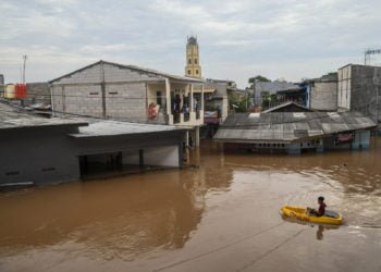 BANJIR. Warga melintas menggunakan perahu saat banjir di kawasan Cipinang Melayu, Jakarta, Rabu (1/1).(ANTARA/GALIH PRADIPTA)