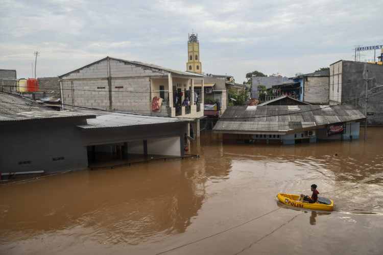BANJIR. Warga melintas menggunakan perahu saat banjir di kawasan Cipinang Melayu, Jakarta, Rabu (1/1).(ANTARA/GALIH PRADIPTA)