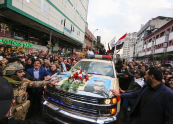 RIBUAN PELAYAT. Para pelayat mengelilingi mobil yang membawa peti mati komandan militer Iran Jenderal Qasem Soleimani dan kepala paramiliter Irak Abu Mahdi al-Muhandis, di Kadhimiya, sebuah daerah ziarah Syiah di Baghdad. (SABAH ARAR/AFP)