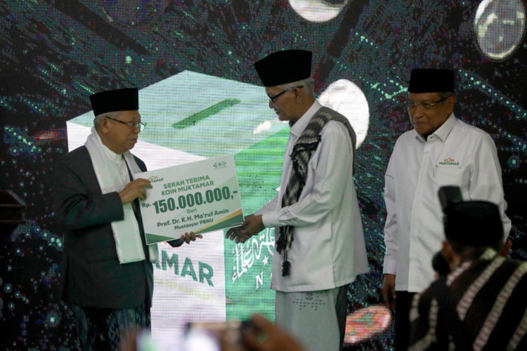 SERAHKAN SUMBANGAN. Wakil Presiden Ma'ruf Amin (kiri) menyerahkan sumbangan pada peluncuran Koin Muktamar kepada Rais Aam PBNU Miftachul Akhyar (tengah) disaksikan Ketua Umum PBNU Said Aqil Siradj saat peringatan hari lahir ke-94 Nahdlatul Ulama (NU) di kantor  PBNU Jakarta, Jumat (31/1).(ANTARA/AFSAL NARENDRA)