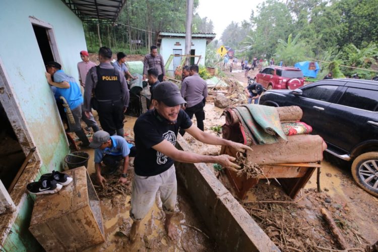 Warga bergotong royong mengangkut barang-barang yang terendam banjir. ABU UMARALY