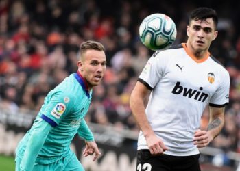 BEREBUT BOLA. Penyerang Valencia, Maxi Gomez (kanan), berebut bola dengan gelandang Barcelona, Arthur Melo, pada lanjutan La Liga Spanyol, Sabtu (25/1) malam WIB. Barcelona takluk di Mestalla, markas Valencia, dengan skor 2-0.(AFP/JOSE JORDAN)