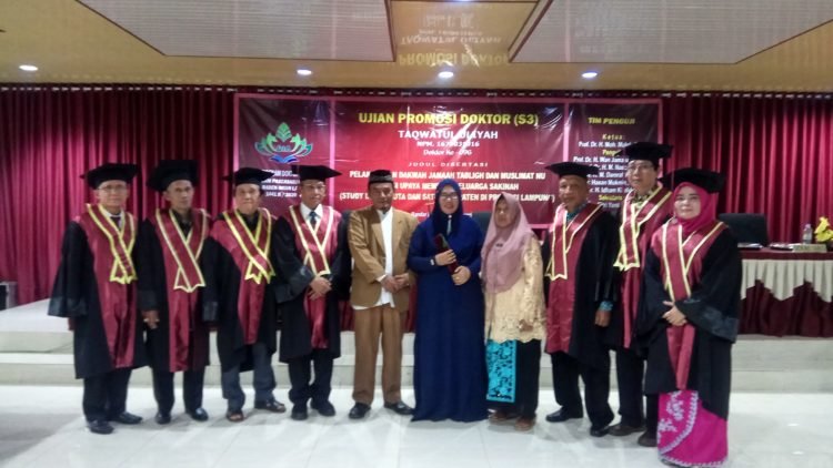 SIDANG DOKTOR. Taqwatul Uliyah (berbaju biru) foto bersama tim penguji sidang promosi doktor UIN Raden Intan Lampung, Rabu (15/1). Taqwatul lulus dengan predikat sangat memuaskan.  (LAMPUNG POST/UMAR ROBBANI)