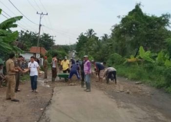 Warga Desa Kekiling bergotong royong menimbun jalan rusak. LAMPUNG POST/AAN KRIDOLAKSONO
