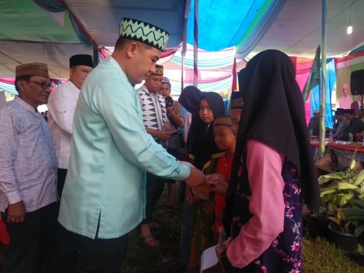 Bupati Pesawaran Dendi Ramadhona saat memberikan santunan kepada anak yatim pada acara Harlah NU ke-94. Lampung Post/ Putra Pancasila Sakti