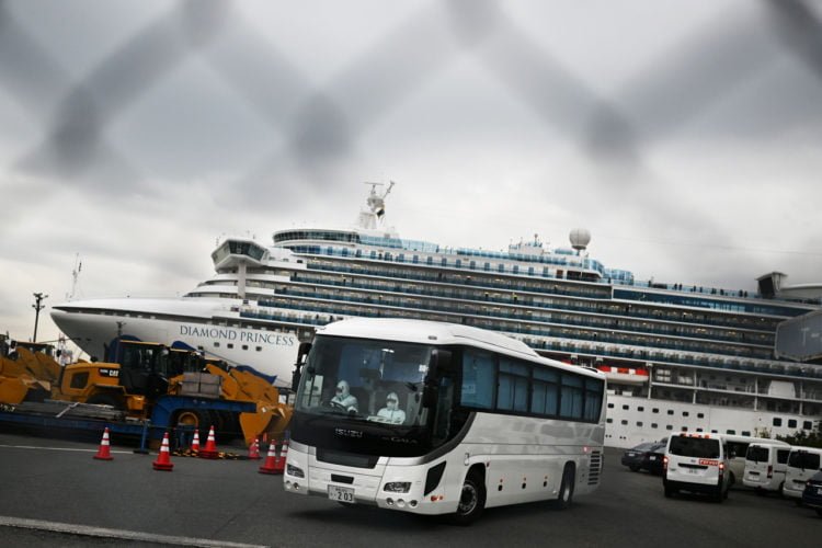 KEMATIAN RENDAH. Sebuah bus dengan sopir yang mengenakan alat pelindung meninggalkan dermaga Pelabuhan Yokohama, Jepang, Jumat (14/2), di sebelah kapal pesiar Diamond Princess yang mengarantina 3.600 orang karena kekhawatiran akan virus corona COVID-19. Kematian akibat virus corona COVID-19 masih rendah dibandingkan SARS dan MERS. (CHARLY TRIBALLEAU/AFP)