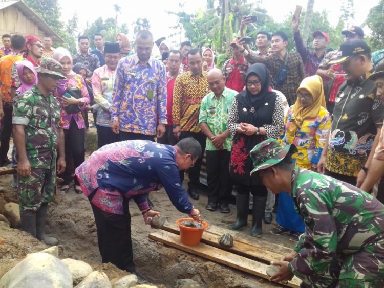 GANDENG KODIM. Bupati Tanggamus Dewi Handayani menggandeng Kodim 0424/TGS memperbaiki rumah korban banjir bandang. n LAMPUNG POST/ABU UMARALY