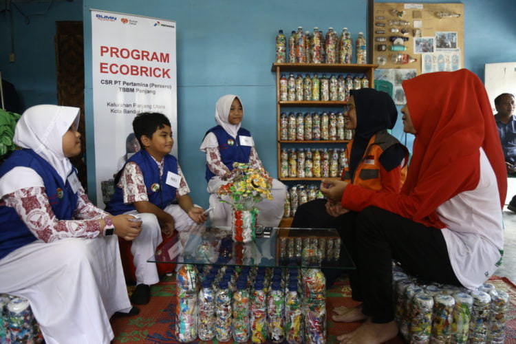 MEMBUAT ECOBRICK. Ketiga Reporter Cilik Lampung Post mewawancarai Ketua Kader Ecobrick Kabarti Ibu Turina (kanan) dan Kak Ayu Kurnia Sari sebagai pendamping para kader, untuk mengetahui cara memanfaatkan botol bekas dengan teknik ecobrick, Kamis (20/2/2020), di Kampung Baru III (Kabarti), Panjang Utara, Bandar Lampung. LAMPUNG POST/ZAINUDDIN