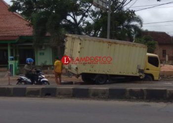 Sebuah truk box tersangkut pada galian pipa proyek SPAM yang berada di Natar, Kamis, 6 Februari 2020. Lampost.co/Deta citrawan