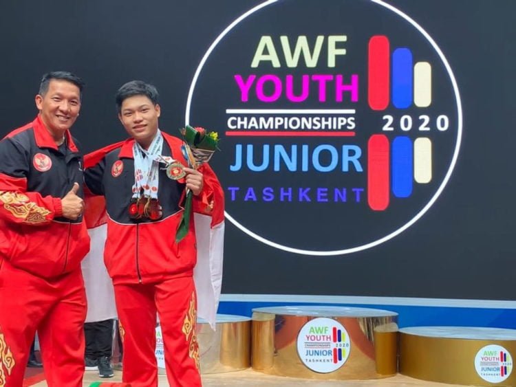 REKOR DUNIA. Lifter Muhammad Faathir  menunjukkan emas yang diraihnya pada kejuaraan Angkat Besi Junior 2020 di Tashkent, Uzbekistan,  Sabtu (15/2) malam. Selain tiga emas, M Faathir juga mencetak dua rekor dunia baru. (LAMPOST.CO/ISTIMEWA)