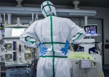 This photo taken on February 24, 2020 shows a doctor looking at a patient infected by the COVID-19 coronavirus at a hospital in Wuhan in China's central Hubei province. - The new coronavirus has peaked in China but could still grow into a pandemic, the World Health Organization warned, as infections mushroom in other countries. (Photo by STR / AFP) / China OUT