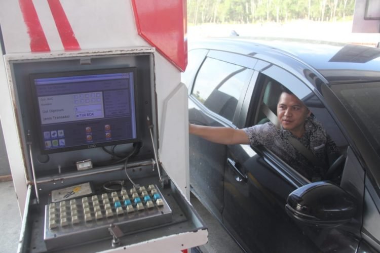 E-TOL. Pengemudi menggunakan kartu e-tol di pintu gerbang Kotabaru Itera Lampung Selatan, Senin (24/2). Hari pertama penerapan dua kartu di Gerbang Tol (GT) Kota Baru masih banyak ditemukan pengendara yang masih melakukan top up di GT.
n LAMPUNG POST/SUKISNO