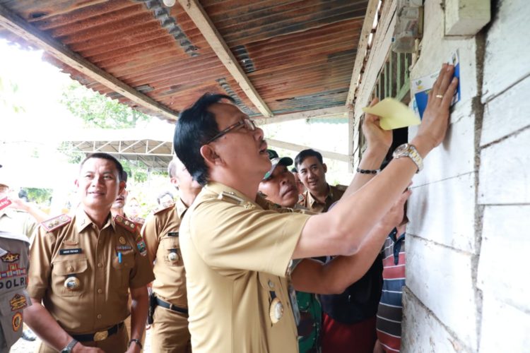 Bupati Pesisir Barat Agus Istiqlal menempelkan stiker penerima PKH di kabupaten itu, seluruh rumah keluarga PKH di pesibar akan dipasang stiker, Senin (10/2).