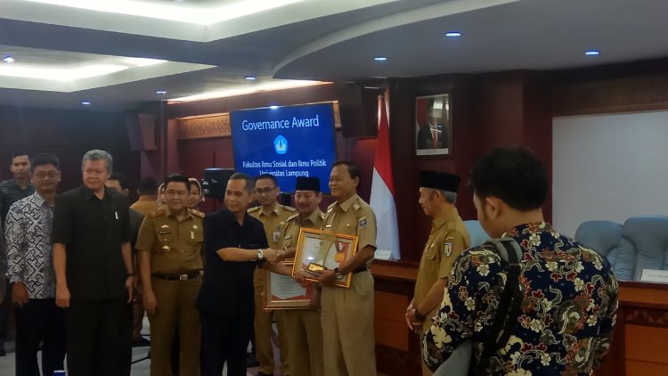 PENYERAHAN PENGHARGAAN. Rektor Unila Karomani menyerahkan penghargaan kepada kepala daerah peraih Governance Award di Rektorat Unila, Selasa (11/2). (LAMPUNG POST/UMAR ROBBANI)