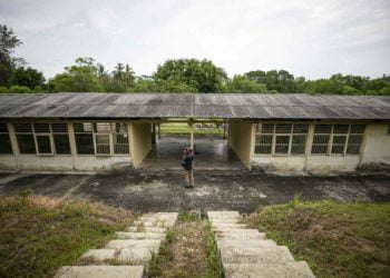 RENCANA PEMBANGUNAN RS KHUSUS CORONA. Warga melihat salah satu bangunan bekas rumah sakit di kawasan wisata eks kamp Vietnam di Pulau Galang, Batam, Kepulauan Riau, Kamis (5/3). Pemerintah berencana membangun rumah sakit khusus bagi penderita corona di lokasi eks pengungsi Vietnam dan pembangunannya ditargetkan rampung dalam waktu satu bulan. ANTARA FOTO/M N KANWA