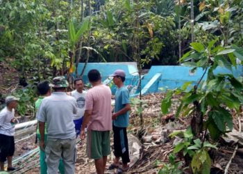 BAK PENAMPUNGAN. Warga melihat bangunan bak penampungan air Way Mis di Desa Tengkujuh, Kecamatan Kalianda, Lampung Selatan, yang diprotes karena merugikan masyarakat, Minggu (3/1). LAMPUNG POST/ARMANSYAH
