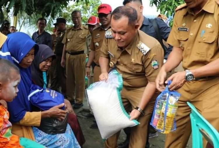 BANTU SEMBAKO. Plt Bupati Lampung Selatan Nanang Ermanto memberikan bantuan sembako kepada korban puting beliung di Desa Munjuk Sampurna, Kecamatan Kalianda, Senin (2/3). LAMPUNG POST/ARMANSYAH