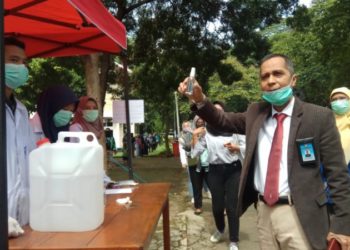 PRODUKSI UNILA. Rektor Unila Aom Karomani menunjukkan penyanitasi tangan buatan mahasiswa FMIPA yang dibagikan di kampus setempat secara gratis kepada masyarakat, Senin (23/3). (LAMPUNG POST/UMAR ROBBANI)
