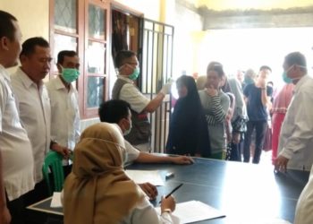 PERIKSA SUHU. Petugas kesehatan Desa Tajimalela, Kecamatan Kalianda, Kabupaten Lampung Selatan, memeriksa suhu tubuh warga setempat di kantor desa, Rabu (1/4). n LAMPUNG POST/AAN KRIDOLAKSONO