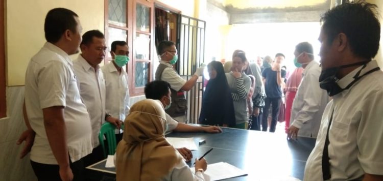 PERIKSA SUHU. Petugas kesehatan Desa Tajimalela, Kecamatan Kalianda, Kabupaten Lampung Selatan, memeriksa suhu tubuh warga setempat di kantor desa, Rabu (1/4). n LAMPUNG POST/AAN KRIDOLAKSONO