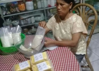 KEMAS PRODUK. Nuryani, perajin jamu instan rumahan, mengemas produk jamu instan rumahan di kediamannya, Rabu (1/4). LAMPUNG POST/YUDHI HARDIYANTO