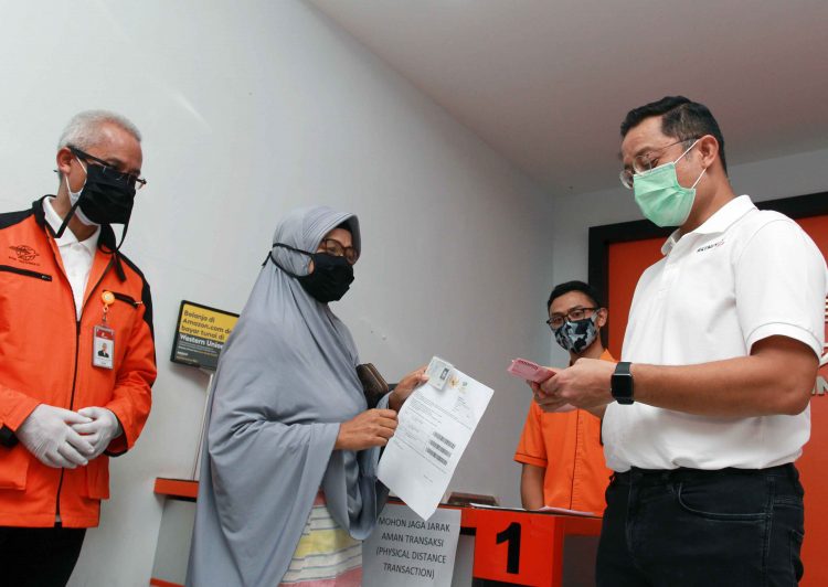 MENSOS TINJAU PENCAIRAN BANTUAN SOSIAL TUNAI: Menteri Sosial Juliari P Batubara (kanan) memberikan uang bantuan pemerintah kepada warga saat meninjau pencairan bantuan sosial tunai (BST) di Curug, Tangerang, Banten, Sabtu (25/4/2020). Bansos berupa uang tunai sebesar Rp600 ribu untuk tiga bulan diberikan kepada keluarga miskin, tidak mampu dan rentan miskin yang terkena dampak wabah COVID-19. Untuk provinsi Banten sebanyak 343.269 warga penerima bantuan tersebut. ANTARA FOTO/Muhammad Iqbal