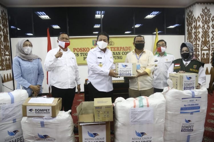 BANTUAN UNTUK LAMPUNG. Pemimpin Redaksi Lampung Post Iskandar Zulkarnain (tiga kanan) menyerahkan bantuan kemanusiaan Peduli Covid-19 Dompet Kemanusiaan (DK) Media Group untuk Provinsi Lampung kepada Gubenur Lampung Arinal Djunaidi (tiga kiri) di Posko Satgas Terpadu Gugus Tugas Penanganan Covid-19 Provinsi Lampung di Gedung Balai Keratun Ruang Abung, kompleks Kantor Gubernur Lampung, Rabu (20/5). Donasi yang disampaikan berupa hazmat 500 buah, sarung tangan 500 pasang, masker KN95 300 buah, goggles 30 RB 300 buah, boots 100 pasang, dan vitamin C 50 kotak.
LAMPUNG POST/ZAINUDDIN