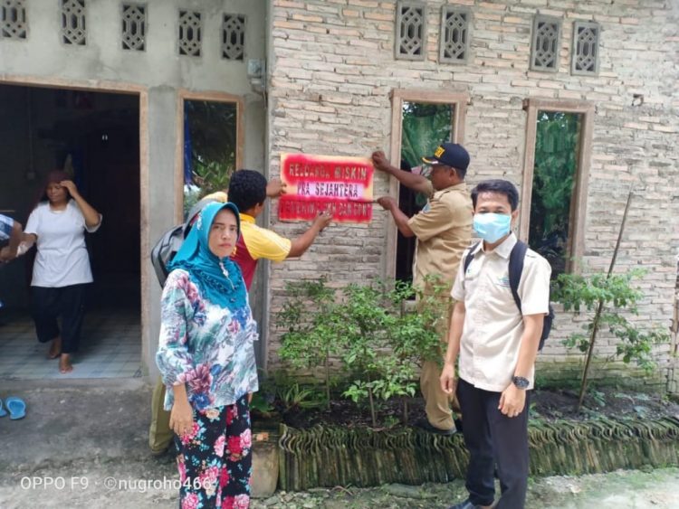 PASANG STIKER. Proses pemasangan stiker atau tanda khusus bagi rumah KPM penerima bantuan PKH dan BPNT di Desa Palasjaya, Kecamatan Palas, Lampung Selatan, Senin (11/5). n LAMPUNG POST/ARMANSYAH