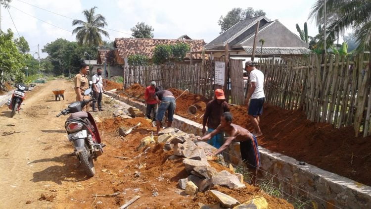 PEMBANGUNAN SIRING. Pekerja informal di Desa Sumberarum, Kecamatan Kotabumi, mengerjakan pembangunan drainase sepanjang 800 meter di jalan poros desa setempat, Rabu (13/5). LAMPUNG POST/YUDHI HARDIYANTO