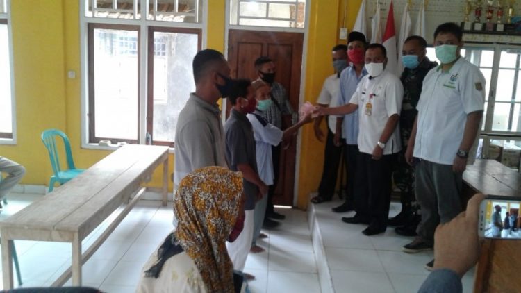 BERIKAN BLT. Kades Kemaloabung, Kecamatan Abung Selatan, Supriono, memberikan BLT dana desa secara simbolis ke warga kurang mampu yang terdampak Covid-19, di kantor balai desa setempat. LAMPUNG POST/YUDHI HARDIYANTO