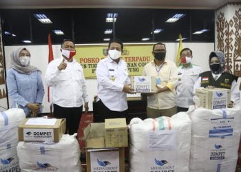 DOMPET KEMANUSIAAN. Pemimpin Redaksi Lampung Post Iskandar Zulkarnain menyerahkan bantuan Dompet Kemanusiaan Media Grup kepada Ketua Tim Gugus Tugas Penanganan Covid-19 Provinsi Lampung Arinal Djunaidi di Gedung Balai Keratun Ruang Abung, kompleks Kantor Gubernur Lampung, Rabu (20/5). (LAMPUNG POST/TRIYADI ISWORO)