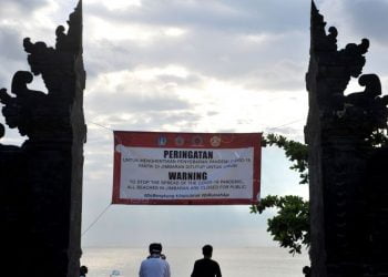 Spanduk penutupan kawasan sementara terpasang di kawasan wisata Pantai Jimbaran, Badung, Bali.  ANTARA FOTO/Fikri Yusuf