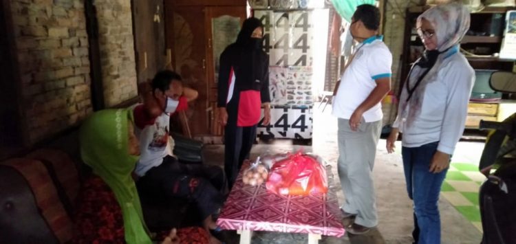 BERIKAN BANTUAN. Tim sukarelawan sosial dari LKS Bina Sejahtera Kecamatan Palas, Lampung Selatan, saat memberikan bantuan sembako kepada Isran dan Aminah, di Desa Palaspasemah, Minggu (17/5). LAMPUNG POST/ARMANSYAH