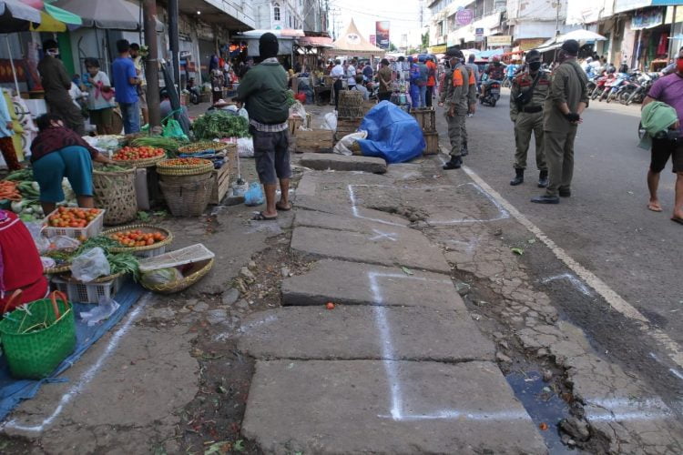 SOCIAL DISTANCING PASAR. Pol PP berjaga di Jalan Imam Bonjol, Tanjungkarang Pusat, dengan menerapkan pembatasan jarak antarpedagang, Jumat (29/5). Berdasar pada imbuan Pemerintah Kota Bandar Lampung untuk terus memaksimalkan social distancing dan physical distancing di lingkungan jual beli seperti pemakaian masker kepada penjual dan pembeli dengan melakukan imbauan lisan.
LAMPUNG POST/ZAINUDDIN